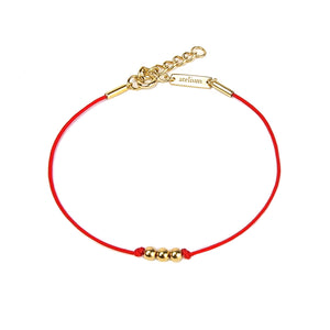 Red string bracelet with 3 gold beads