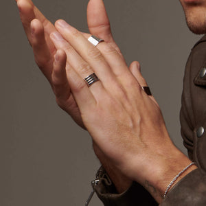 Up close image of man's hands clasped wearing 3 atelium rings