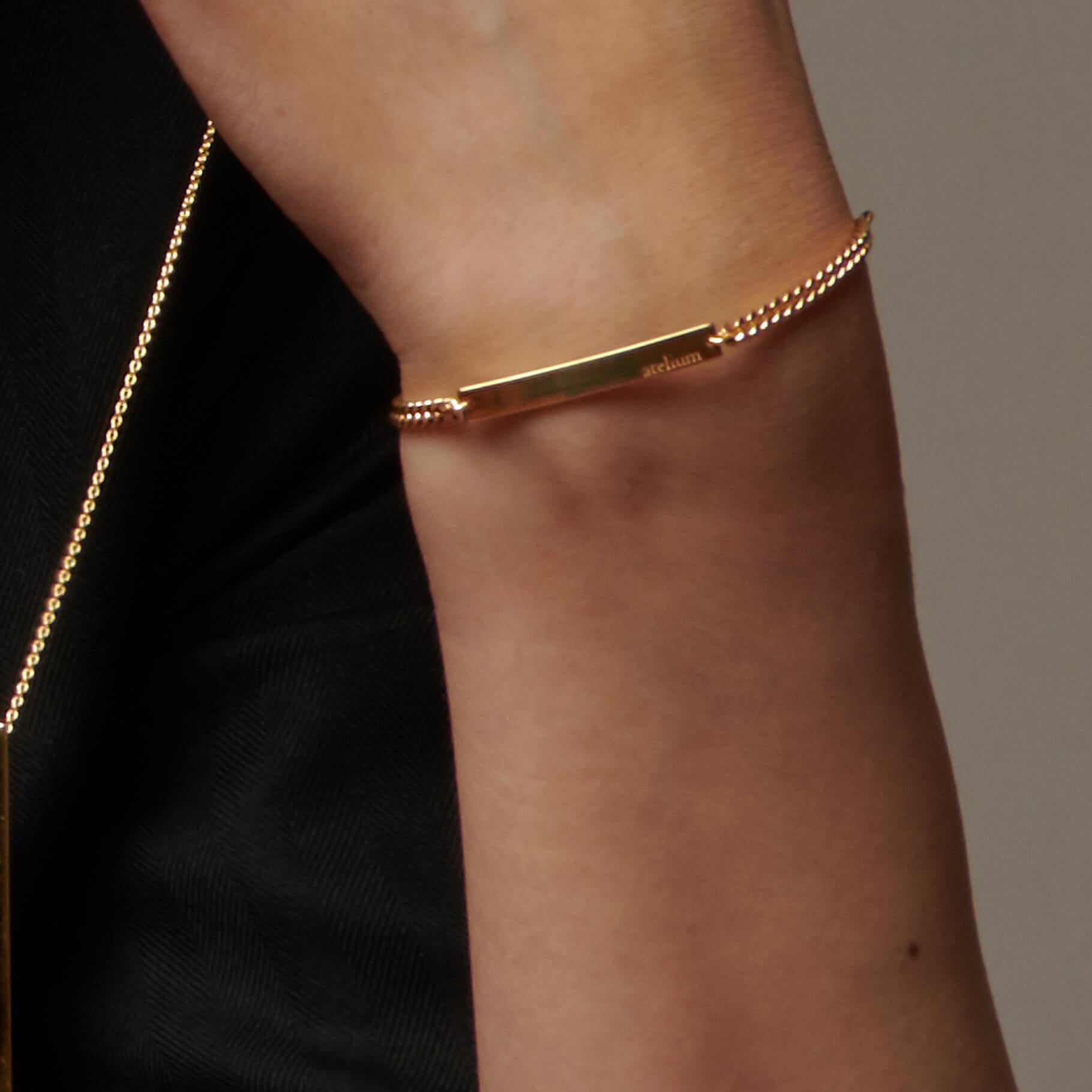Up close image of a wrist wearing atelium gold ID bracelet