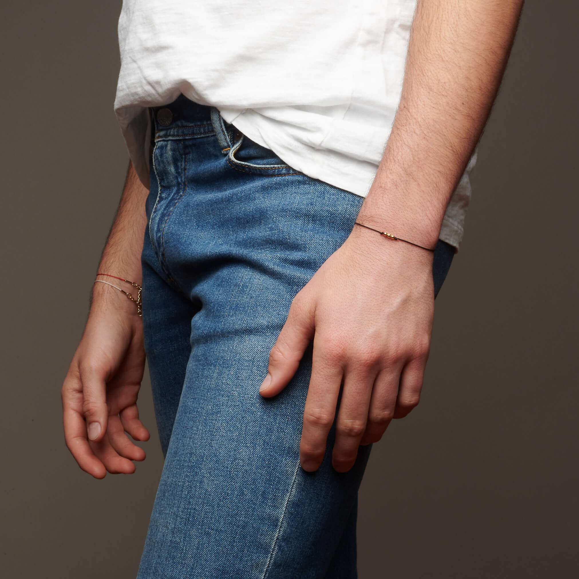 Hands hanging by sides showing sting bracelet on wrist