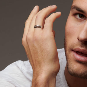 Man's face with hand showing next to it wearing a silver ring