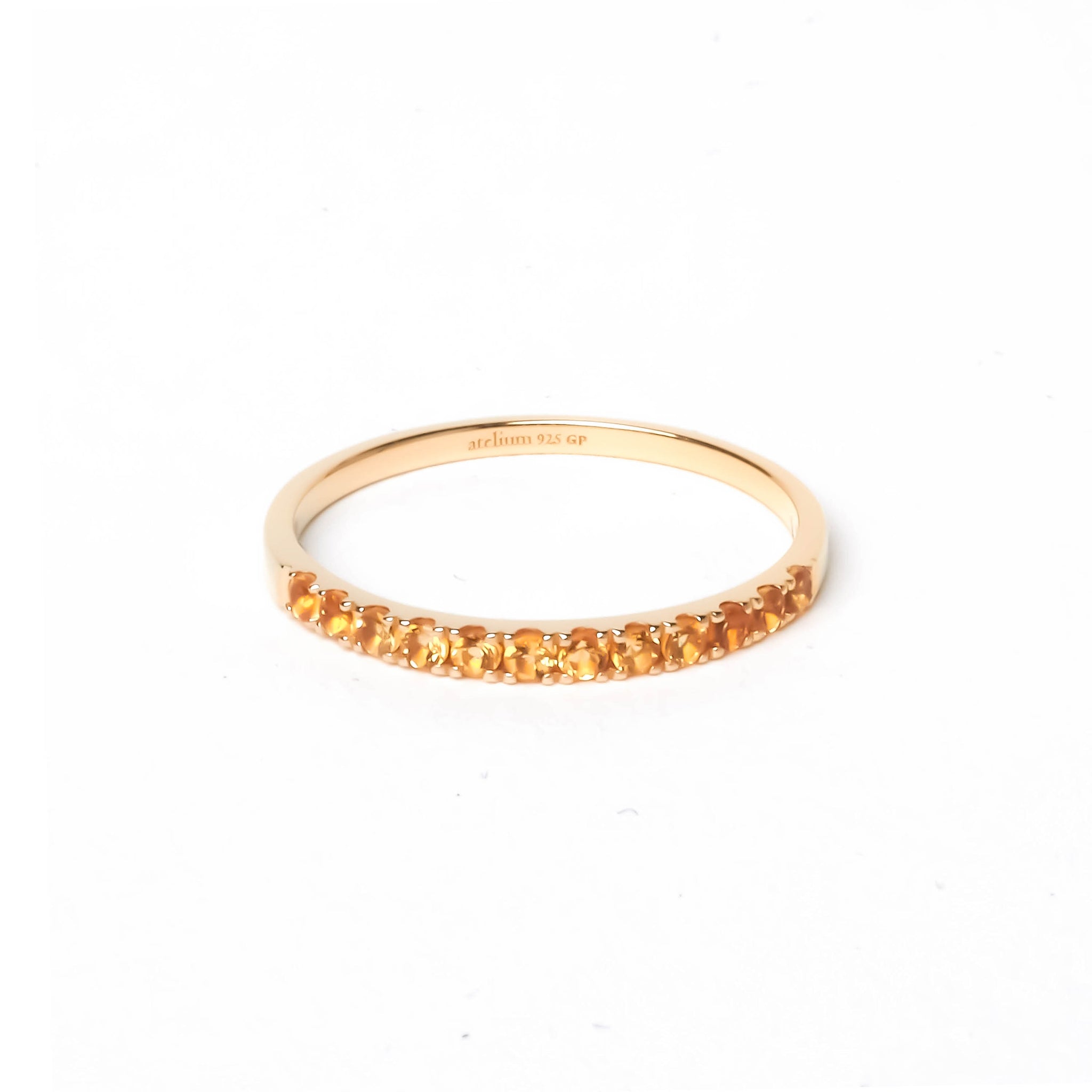 Thin gold ring with multiple citrine gemstones in yellowish orange color